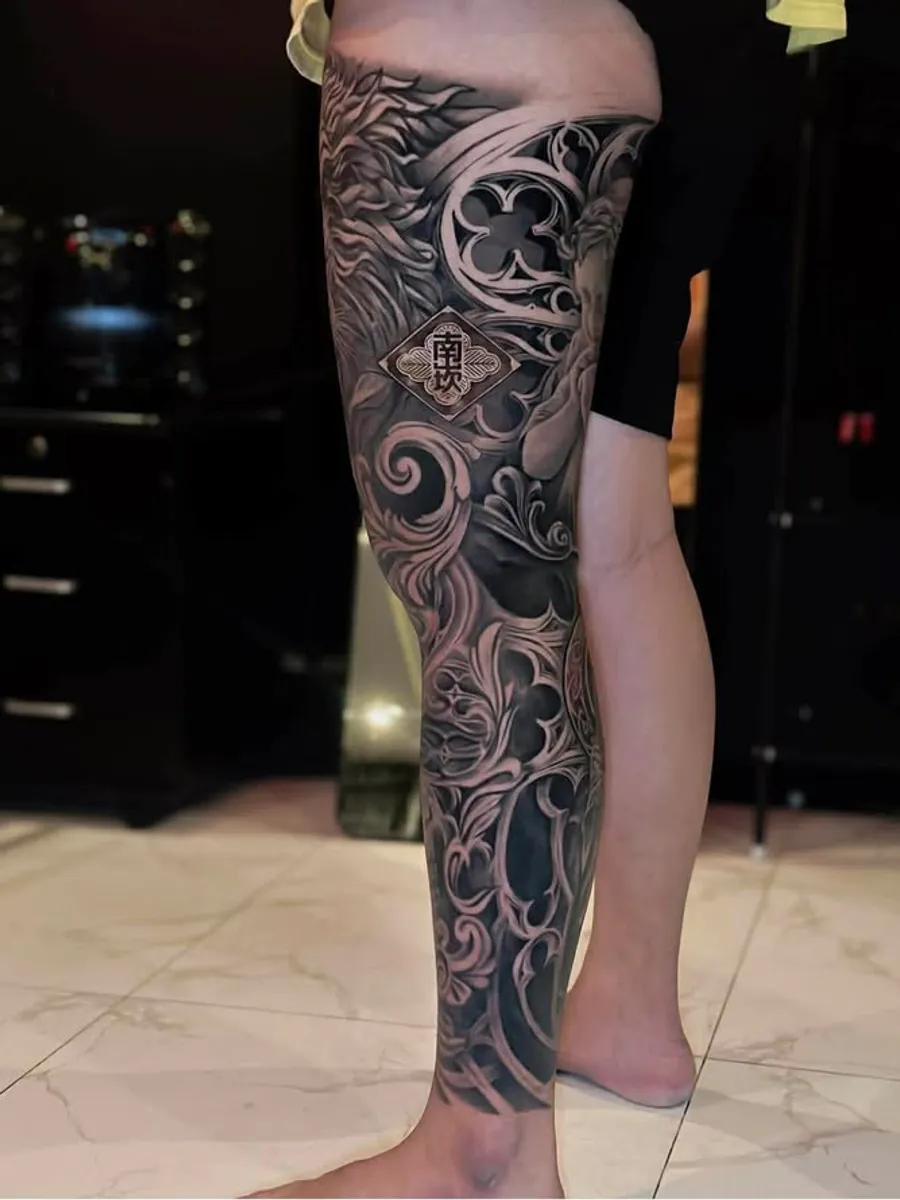 Black and Grey ornamental leg tattoo by RUN INK Tattoo Bangkok